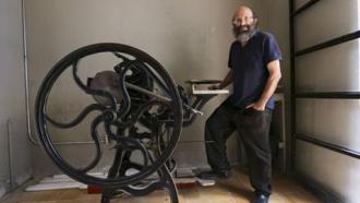 Clemente Orozco stands next to a printing press