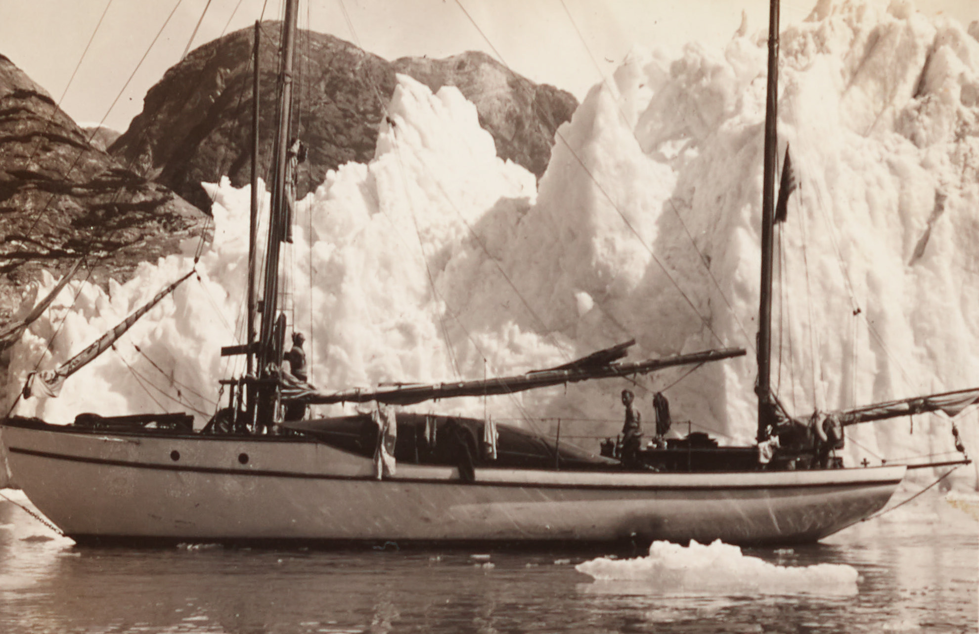 two men on ship near ice with hills in background, taken from page 17r of the album of photographs