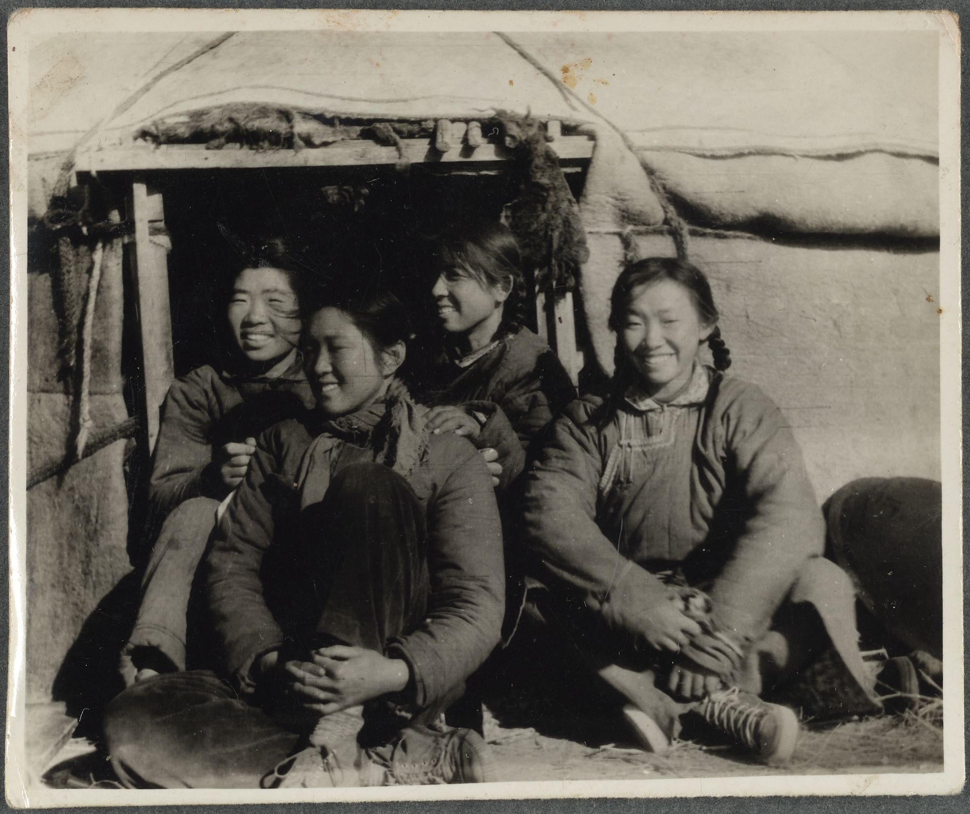 Zengyin Chen and three other youth from Beijing sitting at the door of their small yurt.
