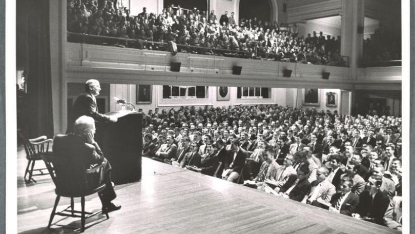 Professor addresses students in large hall