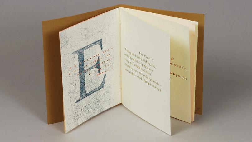 letterpress printed book with large E on left page and poem with vowels punched out on right