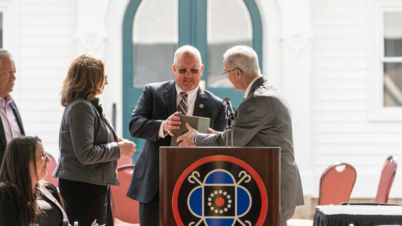 Dartmouth President Philip J. Hanlon ’77 presents Mohegan Tribal Council Chairman James Gessner Jr., center, and other tribal leaders with a box containing some of Samson Occom’s papers at a ceremony in Uncasville, Conn., Occom’s Mohegan homeland, on April 27, 2022.