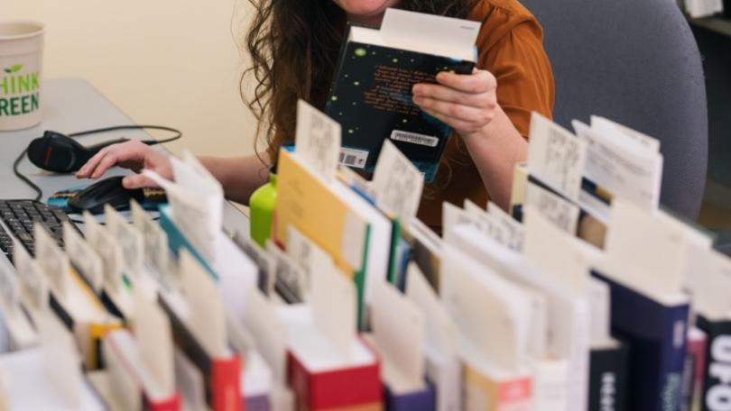 library staff member processes new books in acquisitions department