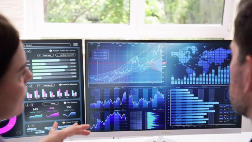two people look at data sets on computers