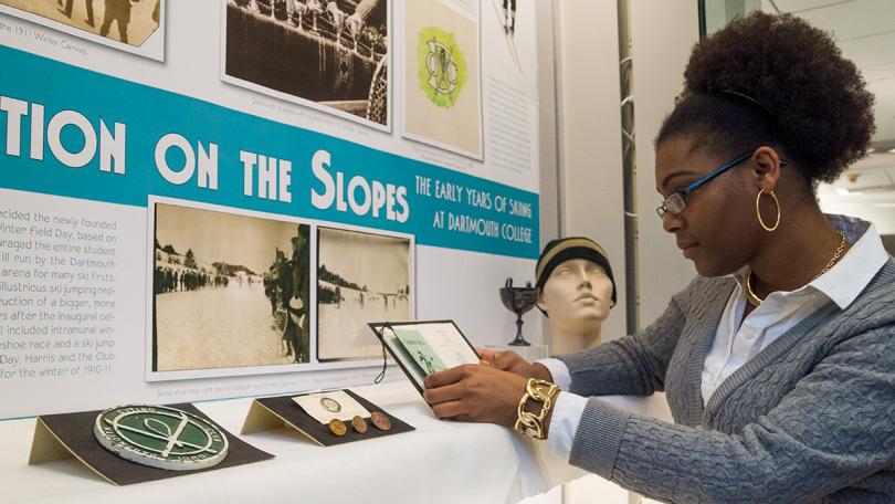 A student exhibit curator installing an exhibit about Dartmouth history.