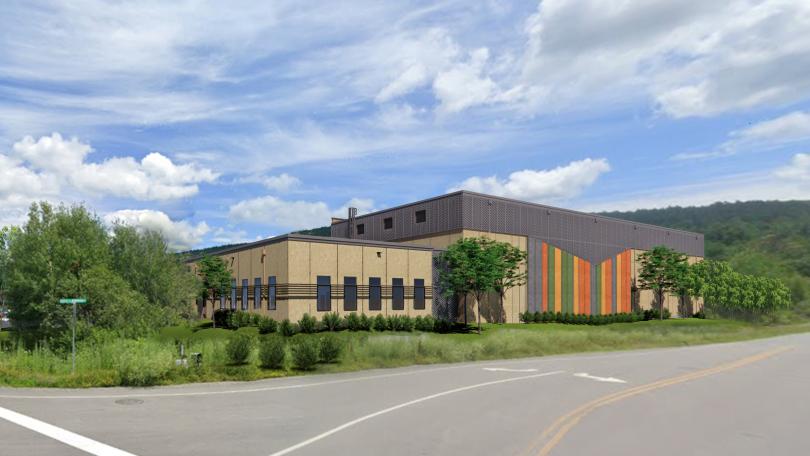 Road in foreground with buildings & trees against blue sky with a few clouds. Proposed buildings for new Library Collecetions and Service Facility.