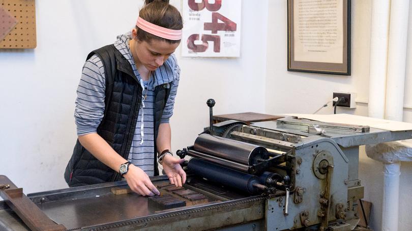 student working on Vandercook press