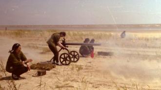Young people shoot a cannon in a field