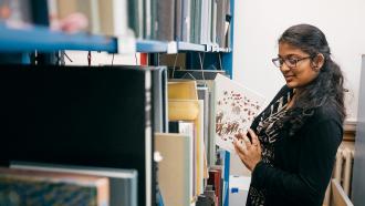 Student taking a book out of a book shelf
