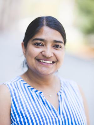 Smiling brown asian women wearing a blue and white striped shirt