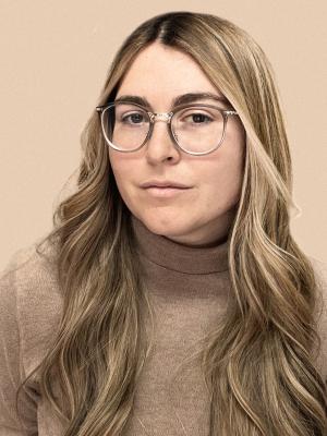 Blonde woman with glasses wearing tan colored shirt