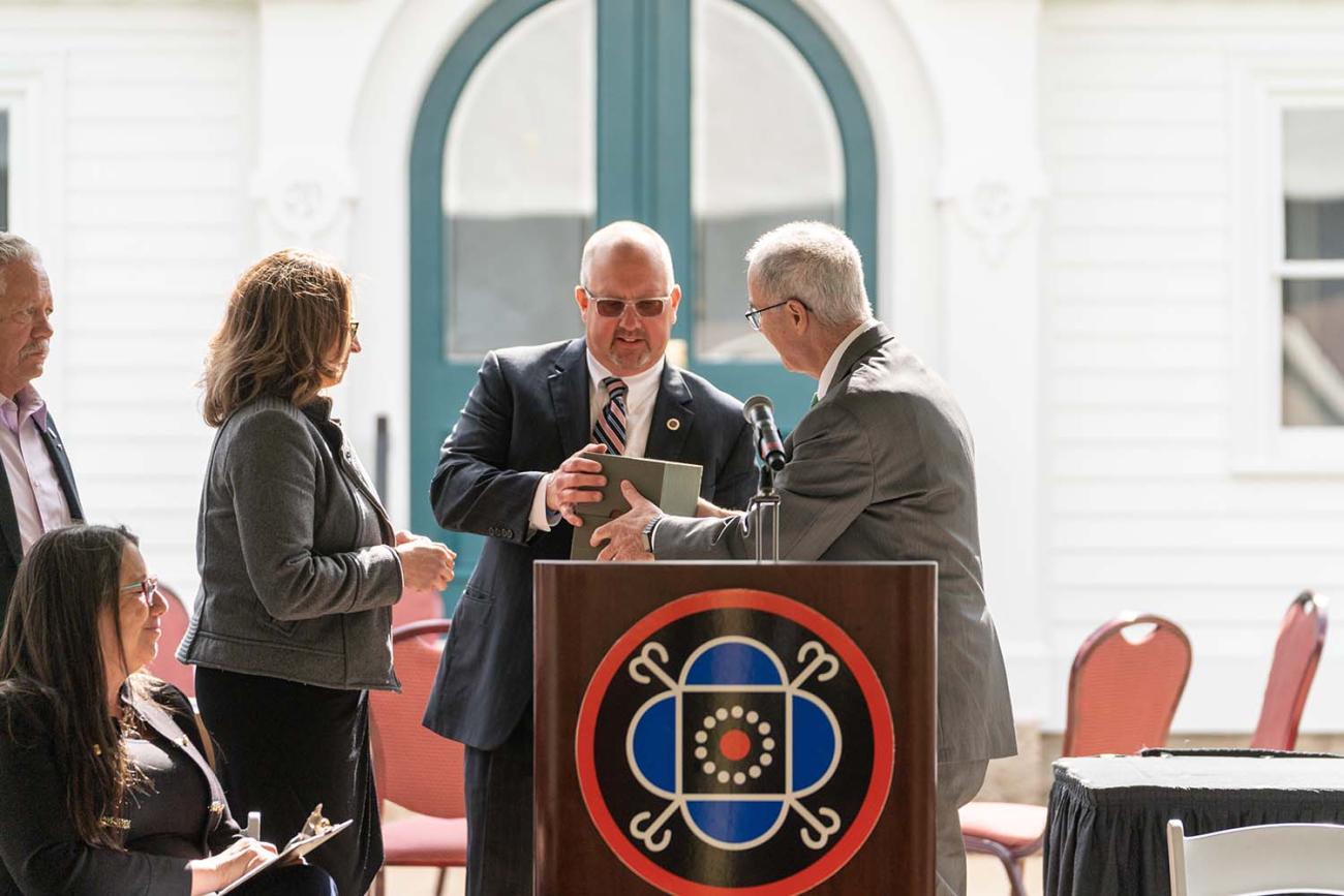 Dartmouth President Philip J. Hanlon ’77 presents Mohegan Tribal Council Chairman James Gessner Jr., center, and other tribal leaders with a box containing some of Samson Occom’s papers at a ceremony in Uncasville, Conn., Occom’s Mohegan homeland, on April 27, 2022.