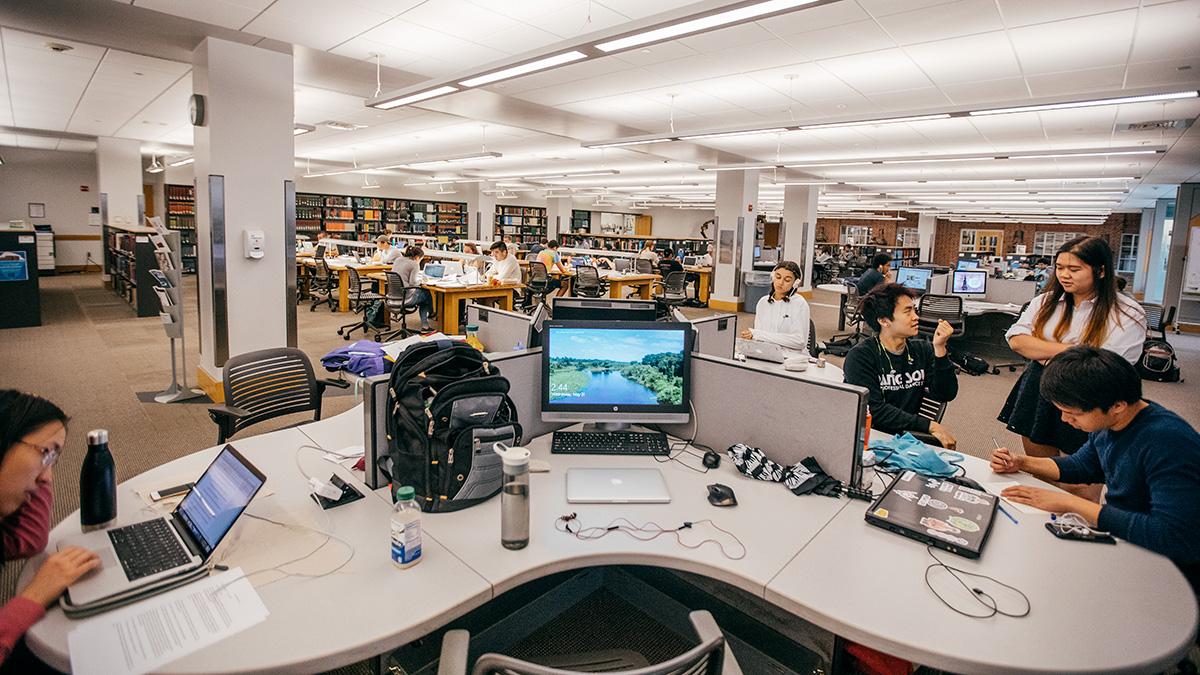 Students talking and studying and computers on desks