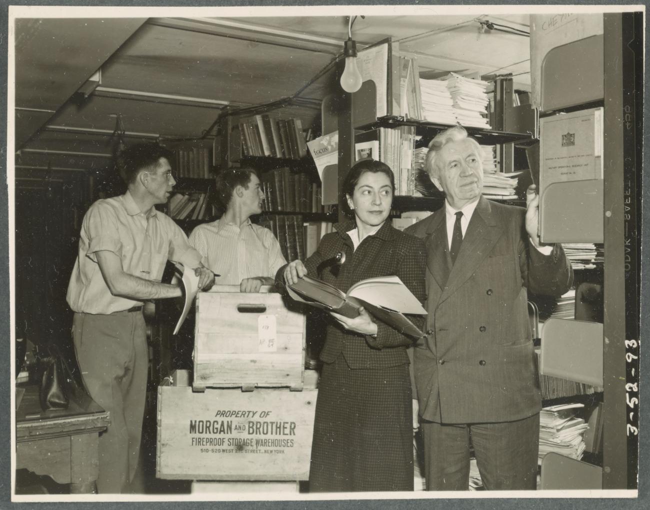 two movers help Evelyn and Vilhjalmur Stefansson unpack their vast polar library at Dartmouth