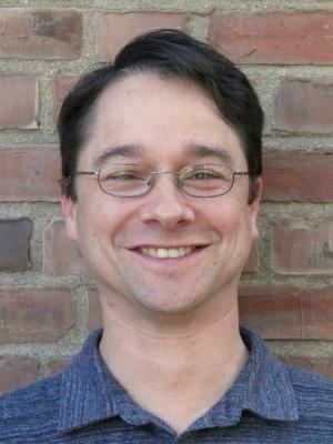 Portrait of Joe in front of a brick wall