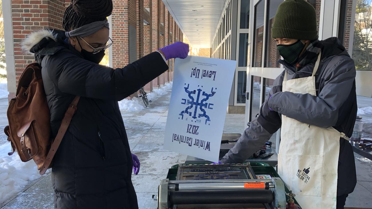 Students printing a Winter Carnival Poster outside Novack Café