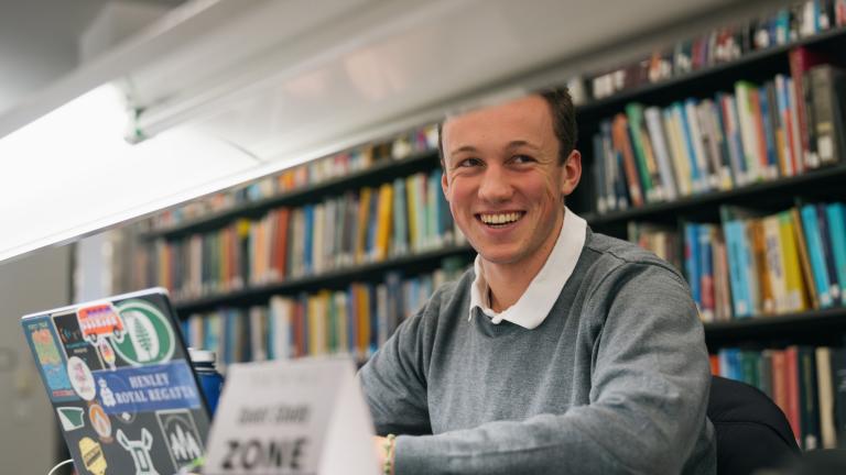 student studying in Berry Library smiles for the camera